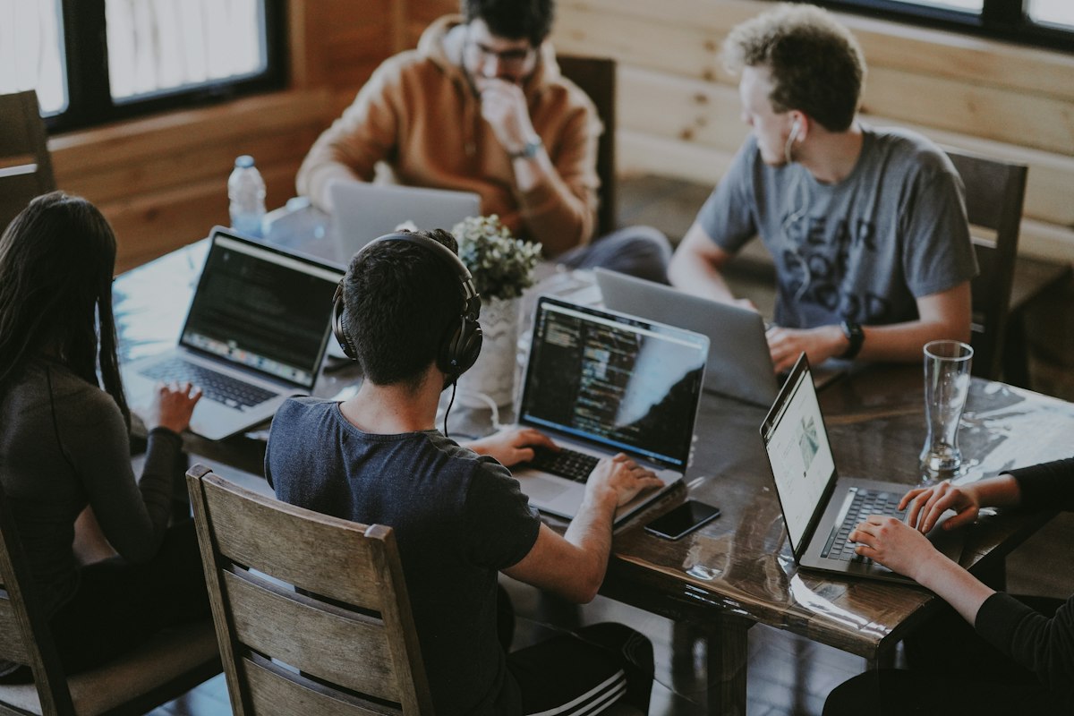 People collaborating around laptops at a shared table
